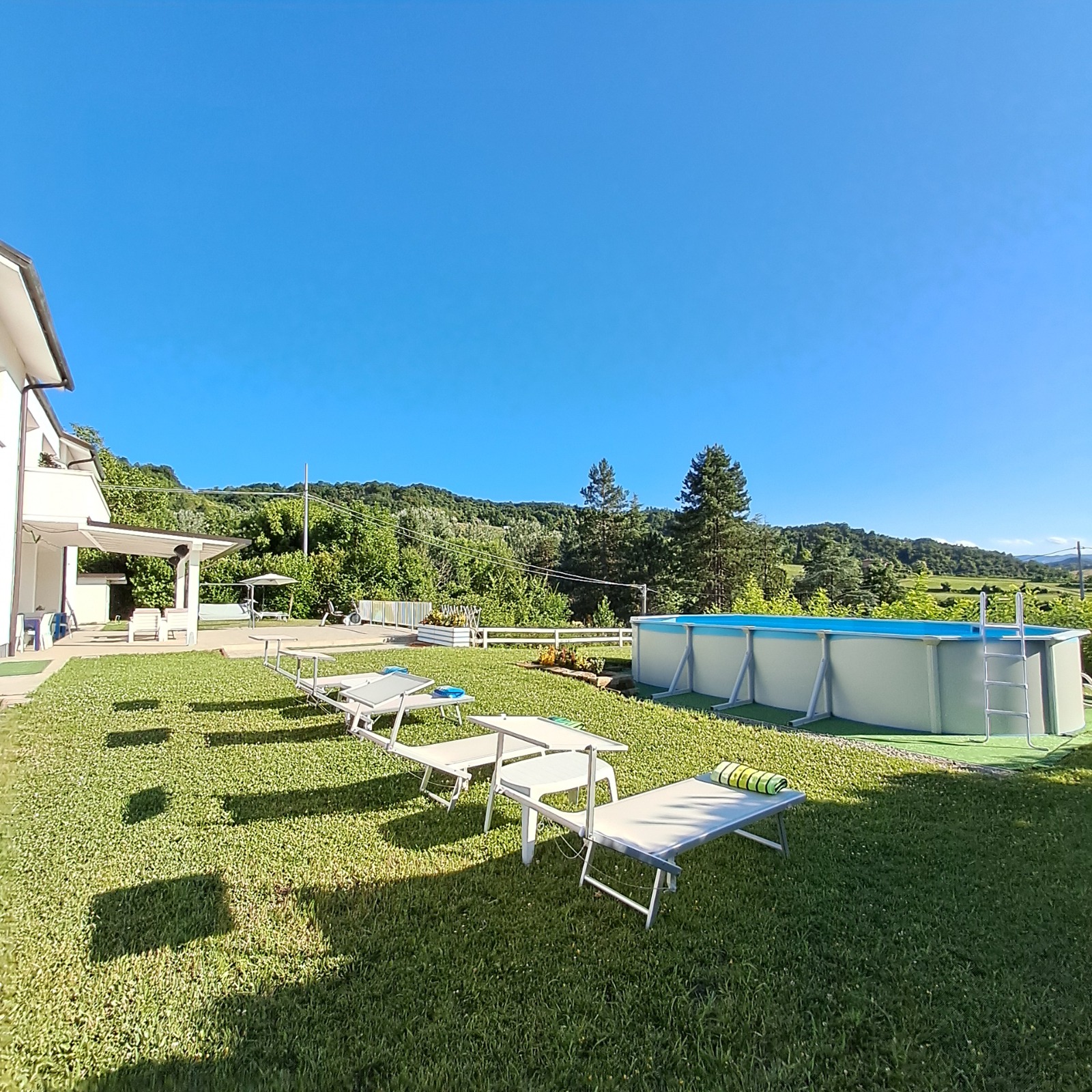 Giardino con lettini prendisole e piscina panoramica al B&B TerrazzaPonente